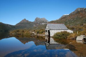 Historic boat shed on Dove Lake with Cradle Mountain peaks in the background on a clear day