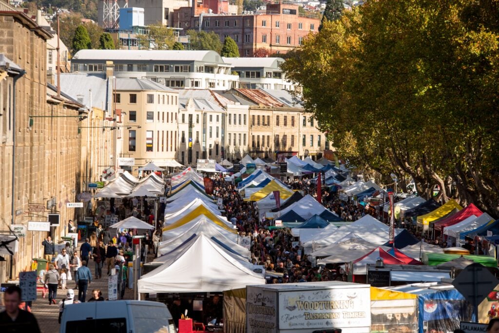 Crowds exploring Salamanca Market in Hobart, Tasmania, with colourful market stalls lining the historic precinct